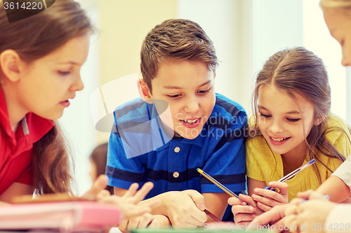 Image of group of students talking and writing at school