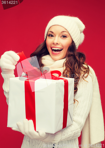 Image of smiling woman in white clothes with gift box
