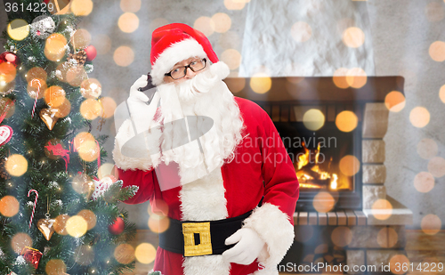 Image of santa claus with smartphone and christmas tree