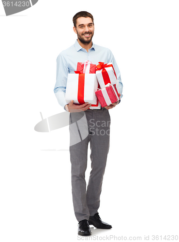 Image of happy young man holding gift boxes