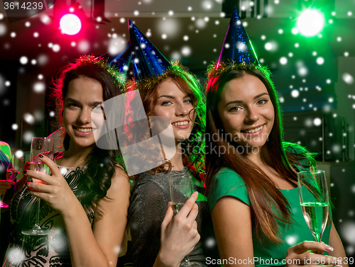 Image of smiling friends with glasses of champagne in club