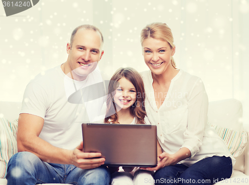 Image of smiling family with laptop at home