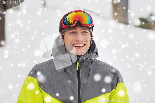 Image of happy young man in ski goggles outdoors