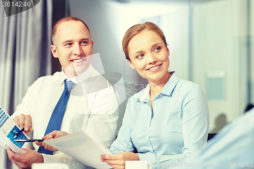 Image of business people with papers meeting in office