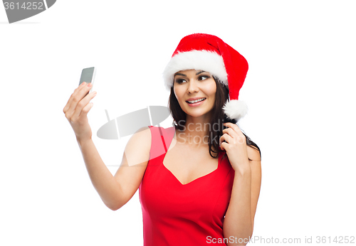 Image of woman in santa hat taking selfie by smartphone