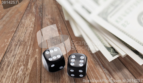 Image of close up of black dice and dollar cash money