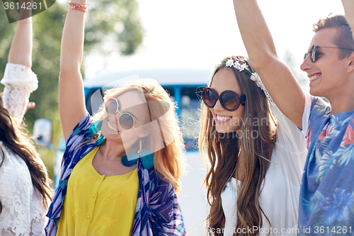 Image of happy young hippie friends dancing outdoors