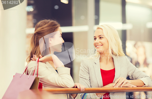 Image of happy young women with shopping bags in mall