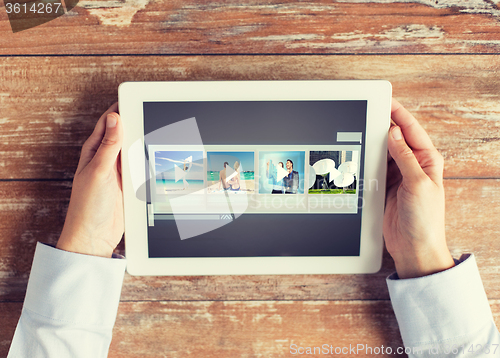 Image of close up of hands with video gallery on tablet pc