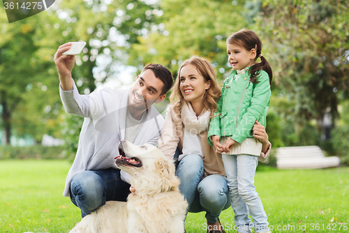 Image of happy family with dog taking selfie by smartphone