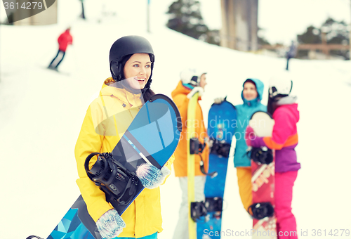 Image of happy friends in helmets with snowboards