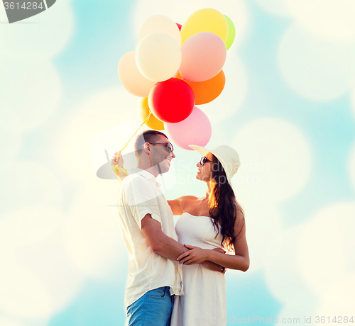 Image of smiling couple with air balloons outdoors