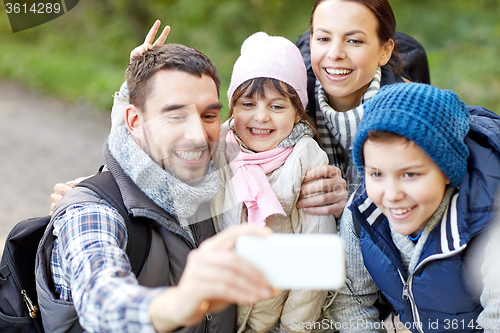 Image of family taking selfie with smartphone in woods