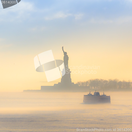 Image of Staten Island Ferry cruises past the Statue of Liberty.