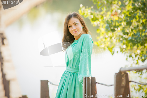 Image of Portrait of slender beautiful girl on the blurry background of the river