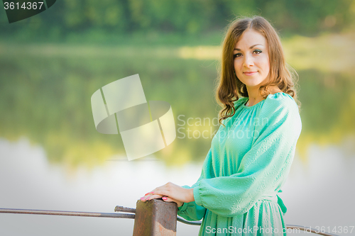 Image of Portrait of a girl on the bridge over the river in the early morning