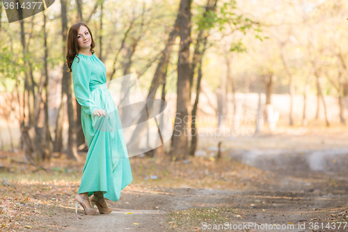 Image of A girl in a long dress walking on the road turned