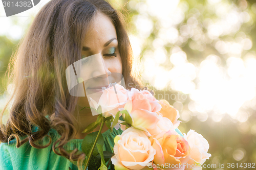 Image of A young girl looks at a bouquet of roses