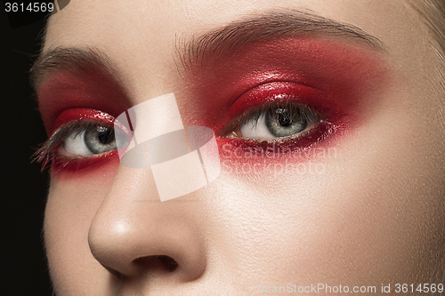Image of Beautiful young female face with bright fashion red make-up