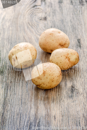 Image of raw baby potatoes on wooden background