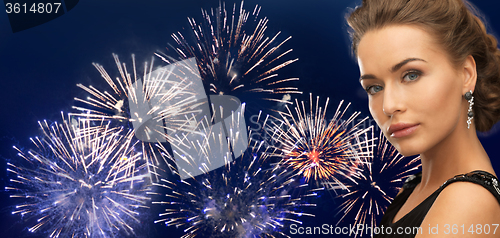 Image of beautiful woman wearing earrings over firework