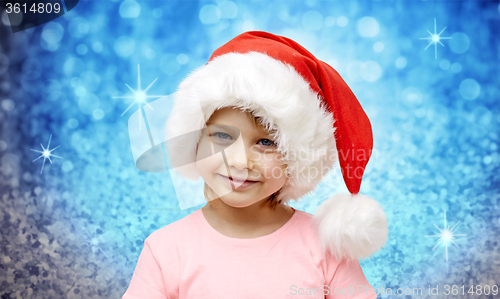 Image of smiling little girl in santa hat at home