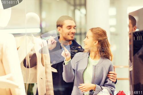 Image of happy young couple with shopping bags in mall