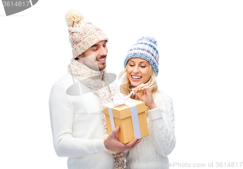 Image of smiling couple in winter clothes with gift box