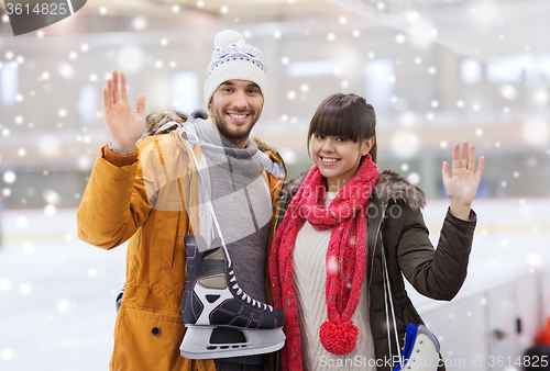 Image of happy couple with ice-skates on skating rink