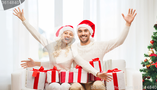 Image of happy couple at home with christmas gift boxes