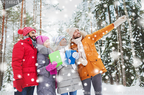 Image of smiling friends with tablet pc in winter forest