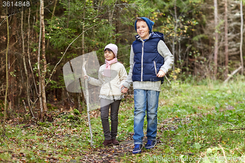 Image of two happy kids walking along forest path