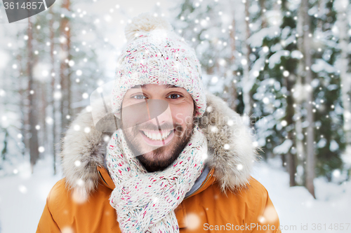 Image of smiling young man in snowy winter forest