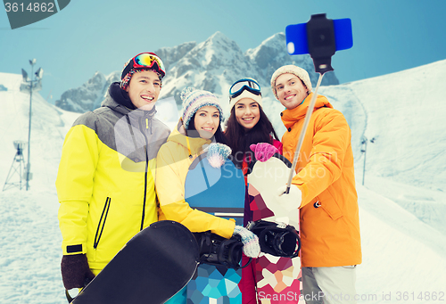 Image of happy friends with snowboards and smartphone