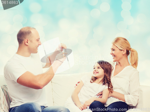 Image of happy family with camera at home