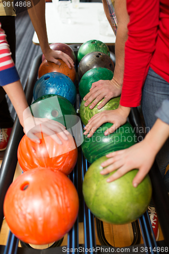 Image of players hands and ball return system in bowling