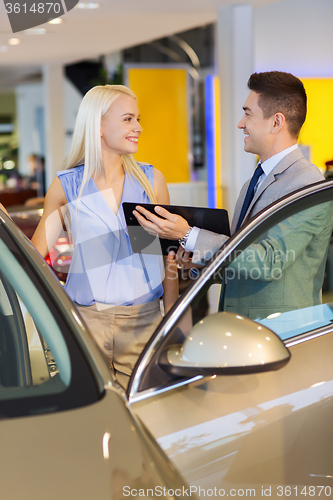Image of happy woman with car dealer in auto show or salon