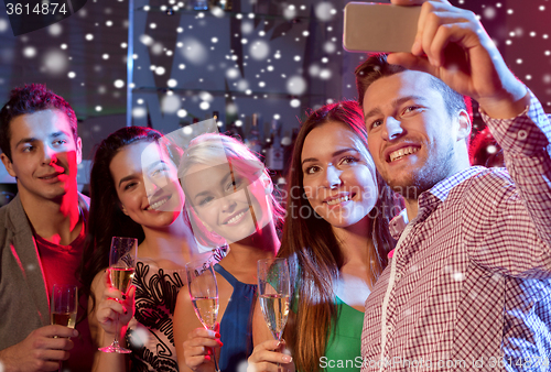 Image of friends with glasses and smartphone in club