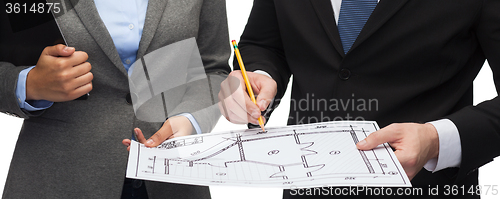 Image of businesspeople with clipboard, blueprint, helmet