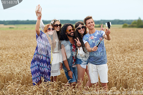 Image of hippie friends with smartphone on selfie stick