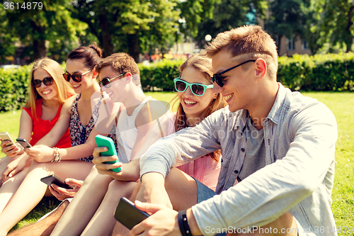 Image of smiling friends with smartphone making selfie