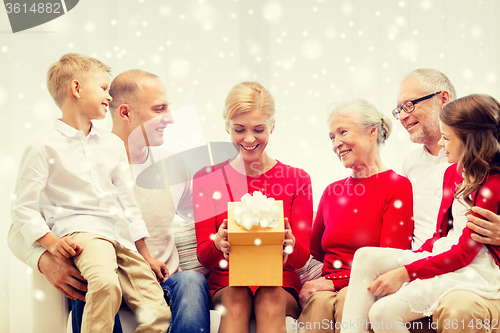 Image of smiling family with gift at home