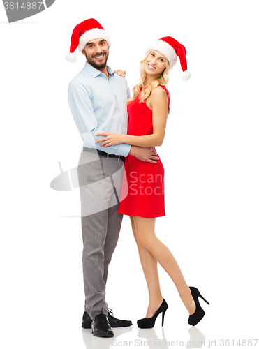Image of happy couple in santa hats hugging