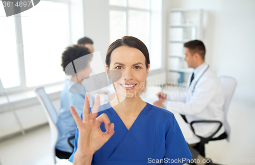 Image of happy doctor over group of medics at hospital