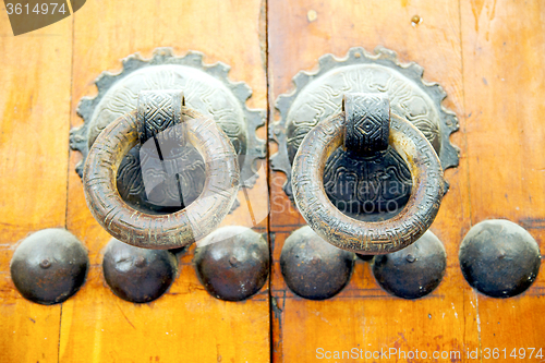 Image of brown  morocco in   facade home and rusty safe padlock 