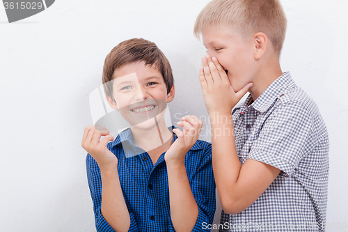 Image of Teenage boy whispering in the ear a secret to friendl on white  background