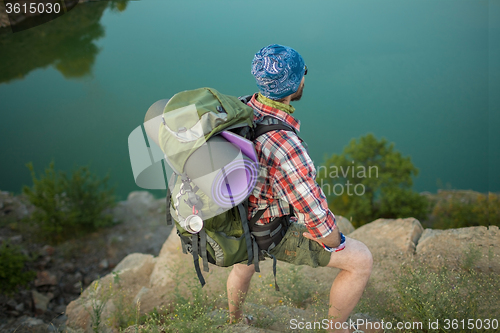 Image of Young caucasian man with backpack on the top of hill