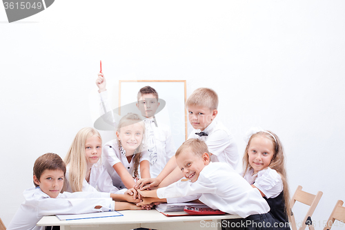 Image of group of teen pupils. They holding their hands together