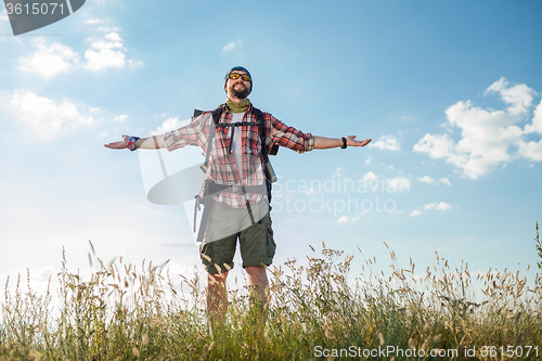 Image of Young caucasian man with backpack standing on the top of hill