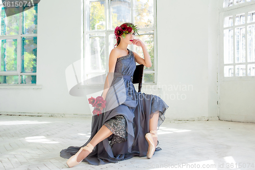 Image of The beautiful ballerina sirtting in long gray dress 